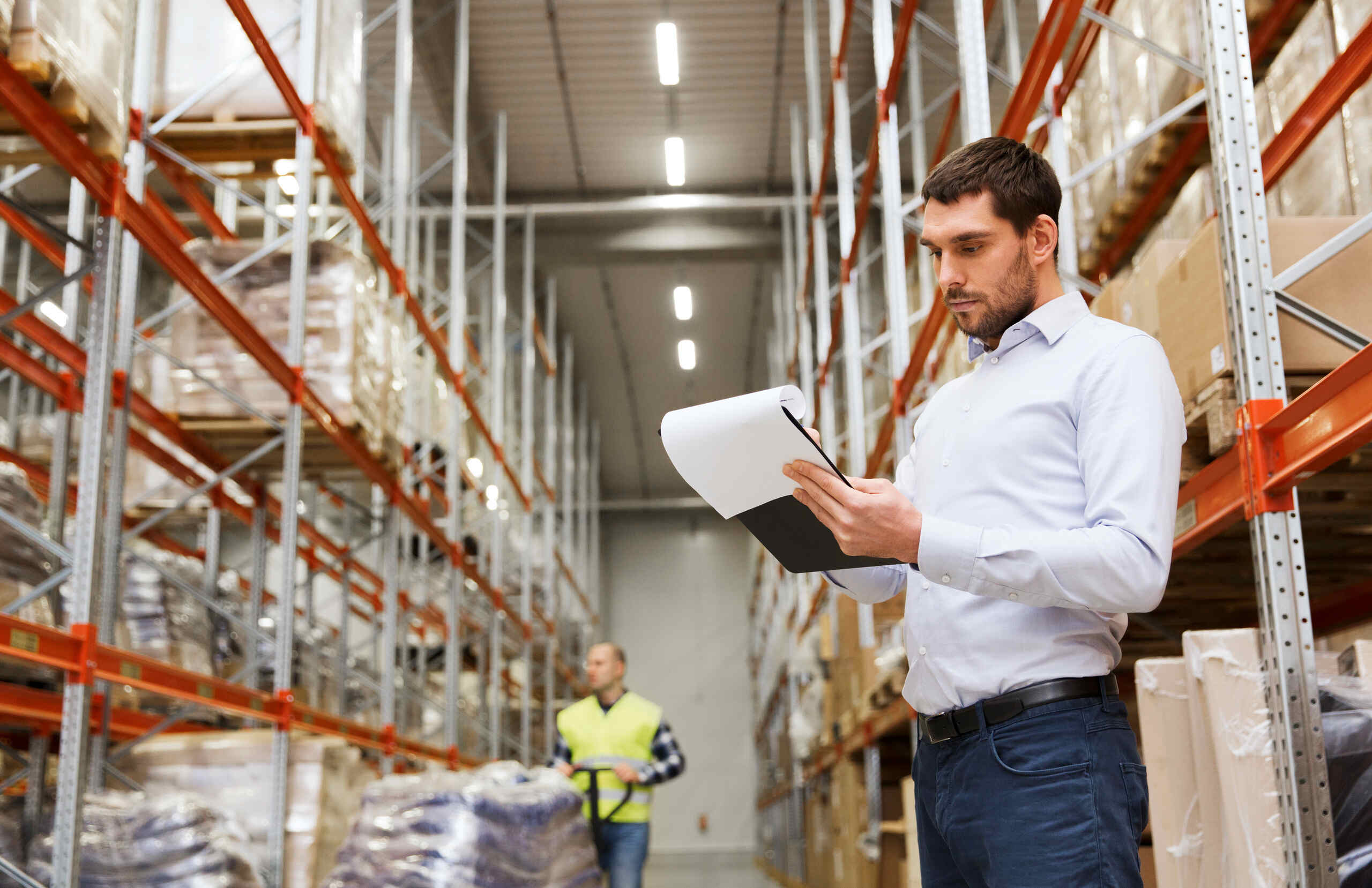 Man in warehouse looking at paperwork