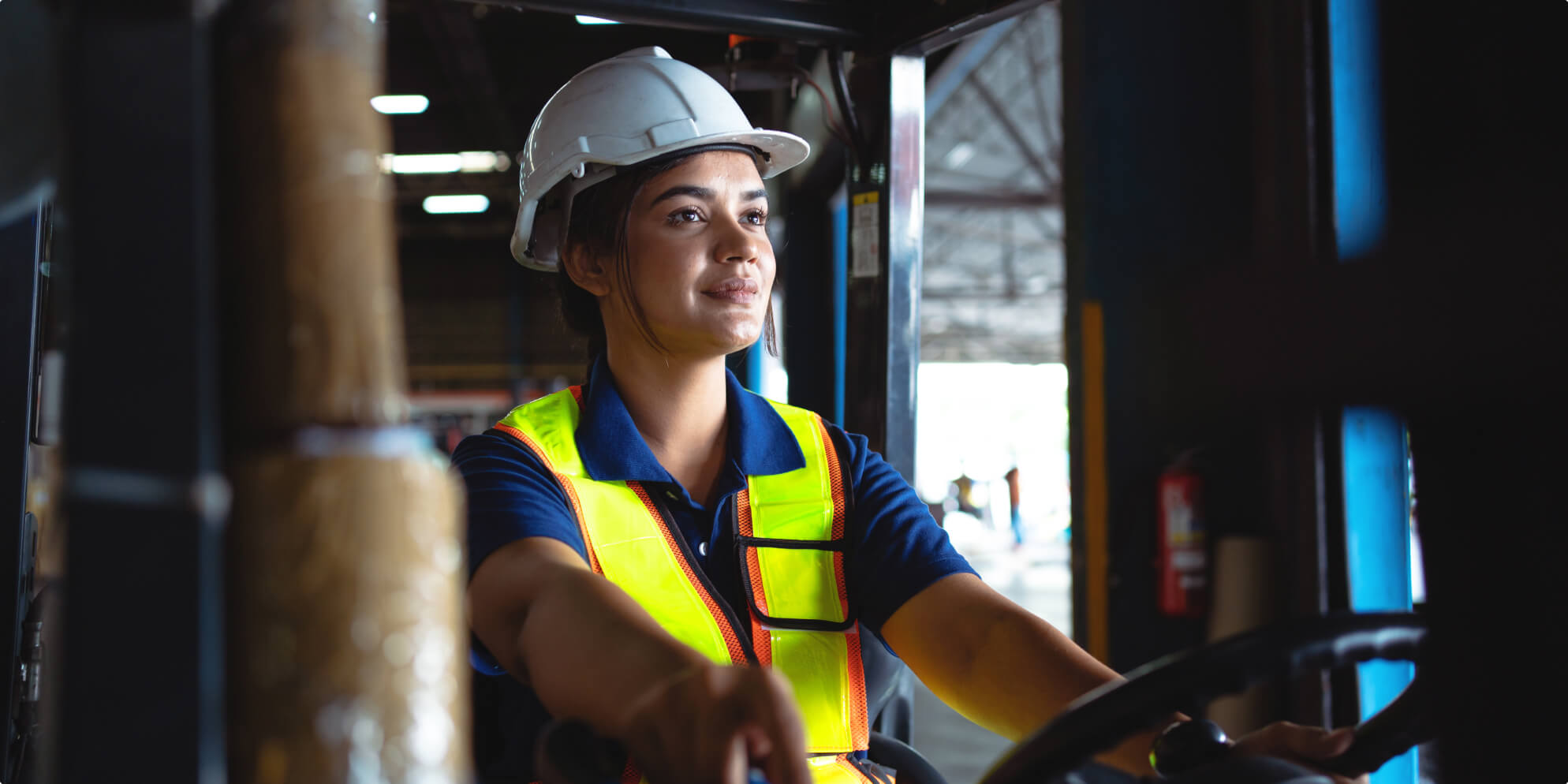 A woman construction worker driving a truck.